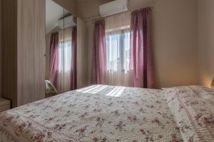 a bedroom with a bed with a flowered blanket and a window at Villa Bali in Kaštelir +20 photos