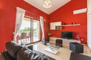 a red living room with a couch and a television at Villa Bali in Kaštelir