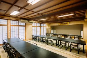 Habitación grande con mesas y sillas. en Hisaeya Ryokan, en Fujioka