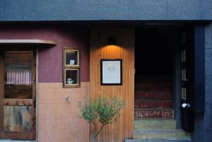 Ten to Sen Guesthouse في تاكاماتسو: باب عمارة عليها زرع
