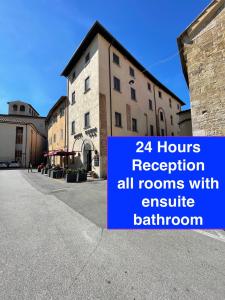 een gebouw met een bord dat de openingstijden van de receptie leest, alle kamers met een exclusieve badkamer bij Hotel Caffè Verdi - 24 hours Reception in Pisa