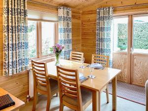 a dining room with a wooden table and chairs at Wheal Metal Lodge in Carleen