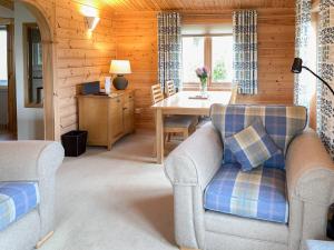 a living room with two chairs and a table at Wheal Metal Lodge in Carleen