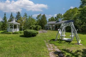a garden with a gazebo and a swing at Dannys Hotel Suites; SureStay Collection by Best Western in Beresford