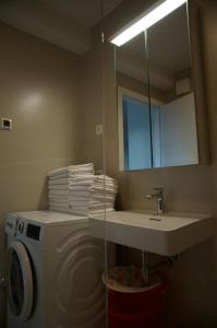 a bathroom with a washing machine and a sink at Nikola Luxury Apartments Borik in Zadar