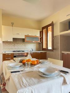 a kitchen with a table with plates and fruit on it at Sunway Apartments 2 in Alghero