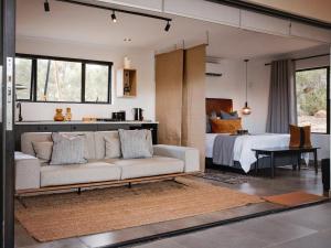 uma sala de estar com um sofá e uma cama em Wagyu Mountain Lodge em Paarl
