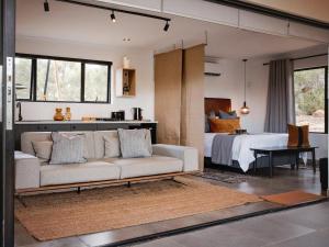 a living room with a couch and a bed at Wagyu Mountain Lodge in Paarl