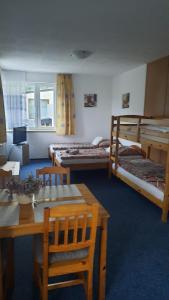 Zimmer mit 3 Etagenbetten sowie einem Tisch und Stühlen in der Unterkunft Apartments Pernink 341 in Pernink