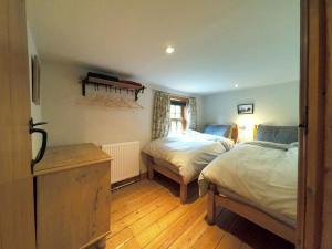 1 Schlafzimmer mit 2 Betten und Holzboden in der Unterkunft Rose Cottage, 2 Bedroom Cottage with character, near Southwold in Wrentham