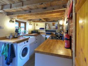 eine Küche mit Waschmaschine und Trockner auf der Theke in der Unterkunft Rose Cottage, 2 Bedroom Cottage with character, near Southwold in Wrentham