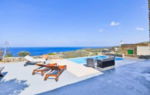 une terrasse avec une table et des chaises et l'océan dans l'établissement Villa Eliza with a swimming pool and sea view in the area of Otzia, on the island of Kea, à Otziás