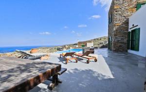 une terrasse avec des chaises, une piscine et l'océan dans l'établissement Villa Eliza with a swimming pool and sea view in the area of Otzia, on the island of Kea, à Otziás