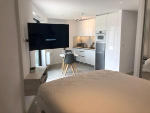 a bedroom with a bed and a kitchen with a television at CP High floor luxury studio with sea view in Gibraltar