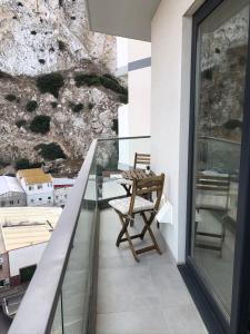 a balcony with a chair and a glass railing at CP High floor luxury studio with sea view in Gibraltar