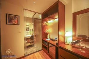 a bathroom with a shower and a desk with a lamp at L'amant de Hanoi Hotel - khách sạn Lamant de Hà Nội in Hanoi