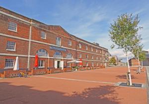 a large brick building with benches in front of it at The Granary in Gosport