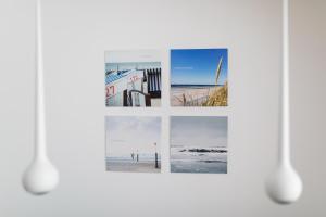 een collage van foto's op een witte muur bij Steg N 5 in Norderney