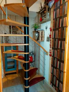 eine Wendeltreppe in einem Zimmer mit Büchern in der Unterkunft Chambres d'hôtes chez sandrine in Rhinau