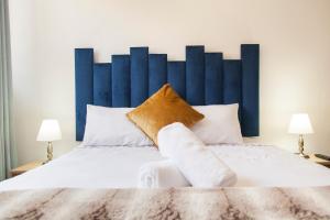 a large bed with a blue headboard in a bedroom at The City Club in Cape Town