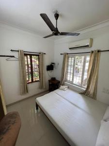 una camera da letto con un grande letto bianco e finestre di seaway's inn a Cochin