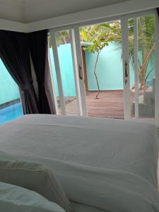 een slaapkamer met een bed en uitzicht op de oceaan bij Villa Giyor in Nusa Lembongan