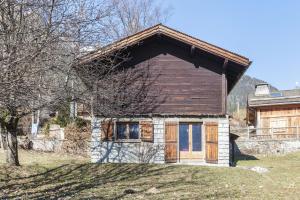 une petite maison avec une porte en bois dans une cour dans l'établissement Petit Chalet Des Moussoux - Happy Rentals, à Chamonix-Mont-Blanc