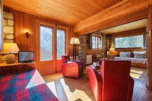 - un salon avec des chaises rouges et un canapé dans l'établissement Petit Chalet Des Moussoux - Happy Rentals, à Chamonix-Mont-Blanc
