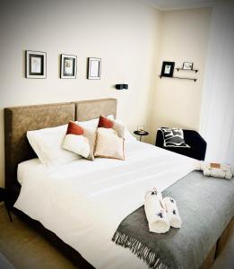Un dormitorio con una cama blanca con zapatillas. en Lucentum en Prato