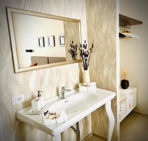 uma casa de banho com um lavatório e um espelho grande em Lucentum em Prato