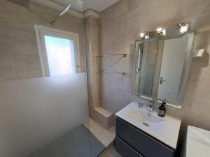 ein Bad mit einem Waschbecken und einem Spiegel in der Unterkunft Magnifique T3 - Saint-Clair - 500m de la plage in Le Lavandou