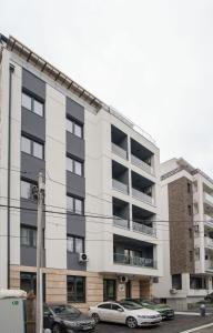 un edificio de apartamentos con coches estacionados frente a él en Pegasus apartments en Belgrado