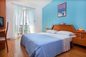 1 dormitorio con 1 cama con pared azul en Villa Rosa, en Makarska