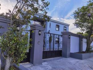 a blue and white house with a black gate at Victoria Guest Lodge in Bellville