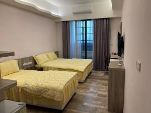 馬公市にあるShun Cheng Hotelのベッド2台とテレビが備わるホテルルームです。