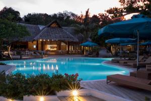 a pool at night with tables and umbrellas at Bluewater Sumilon Island Resort in Sumilon Island
