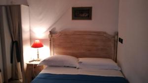 a bedroom with a bed with a wooden headboard and a lamp at Domus B&B in Modugno