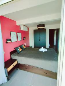 カップ・ダグドにあるCap d'Agde Naturiste Fの赤い壁のベッドルーム1室(大型ベッド1台付)