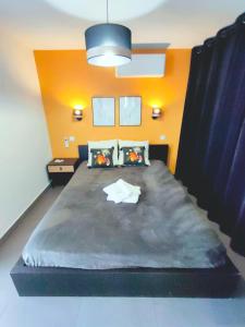 a bedroom with a large bed with an orange wall at Cap d'Agde Naturiste F in Cap d'Agde