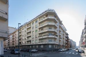 un gran edificio de apartamentos con coches aparcados en la calle en Casa Torricelli in zona Crocetta by Wonderful Italy en Turín