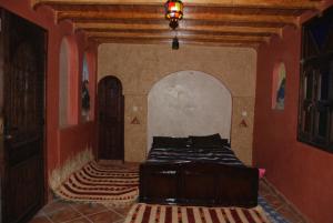 ein Schlafzimmer mit einem Bett in der Mitte eines Zimmers in der Unterkunft Gite Kasbah Tiznit in Tiznit