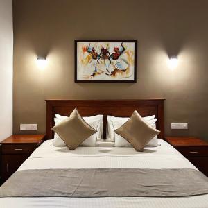 1 dormitorio con 1 cama grande con sábanas y almohadas blancas en Cliveland Residence, en Kandy