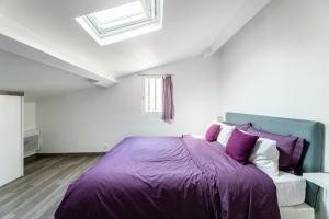 a bedroom with a purple bed and a window at Lou Palmieri in Marseille