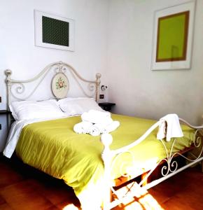 a bedroom with a white bed with a yellow blanket at San Martino - Casa Landi in Castellina in Chianti