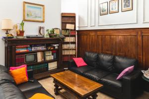 a living room with a black leather couch and a table at Ostello Domus Civica in Venice