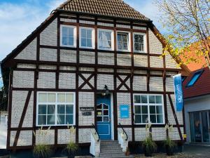 uma casa de enxaimel com uma porta azul em Kajüthus Apartment 5 em Fehmarn