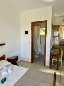a bedroom with two beds and a desk and a bathroom at Alexandra’s Studios Sunset View in Argostoli +80 photos