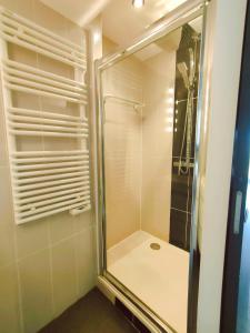 La salle de bains est pourvue d'une douche avec une porte en verre. dans l'établissement Cap d'Agde Naturiste F, au Cap d'Agde