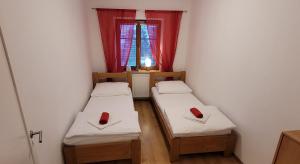 2 Betten in einem kleinen Zimmer mit Fenster in der Unterkunft Apartmany U Lva in Prachatice