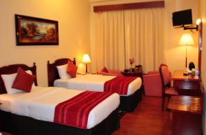 Fortune Deira Hotel tesisinde bir odada yatak veya yataklar